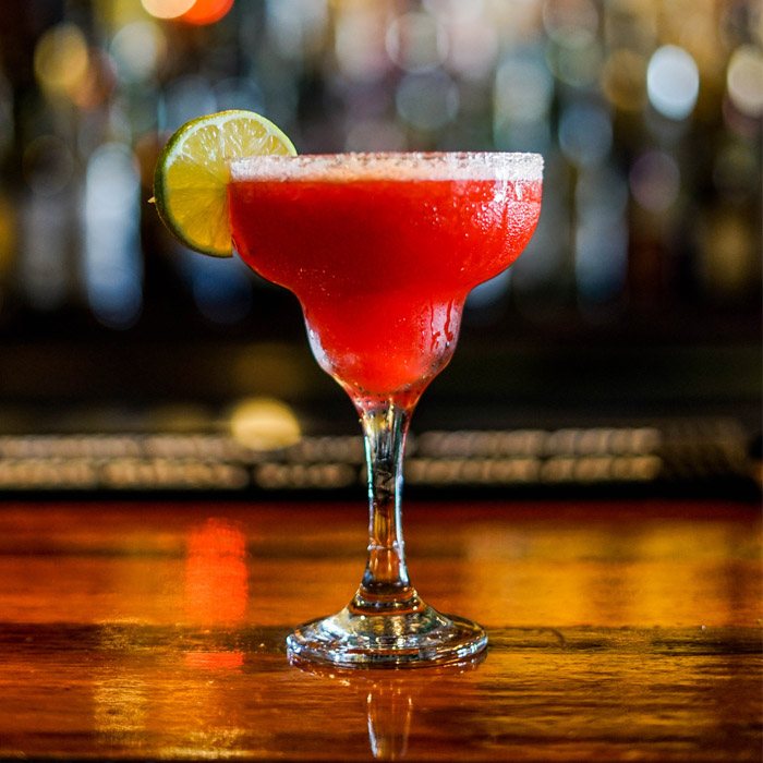 Cocktail rouge dressé sur un comptoir de bar